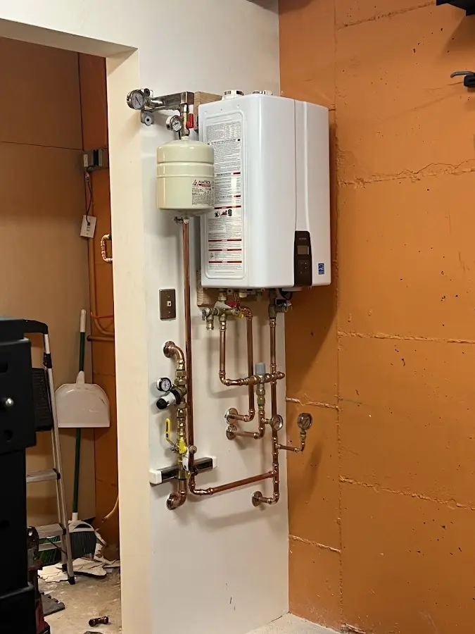 Plumbing technician inspecting water heater connections in Silverthorne